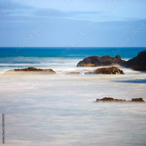 Los Hervideros, volcanic coastline with wavy ocean and blue sky, Long time exposure