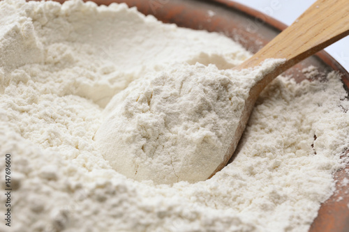 Taking wheat flour from bowl, closeup