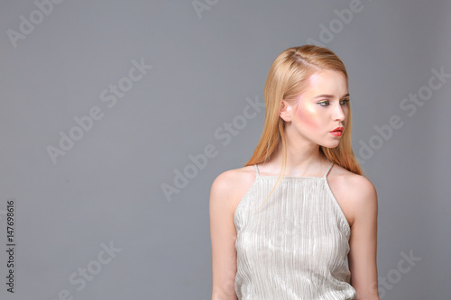 Beautiful young woman on grey background