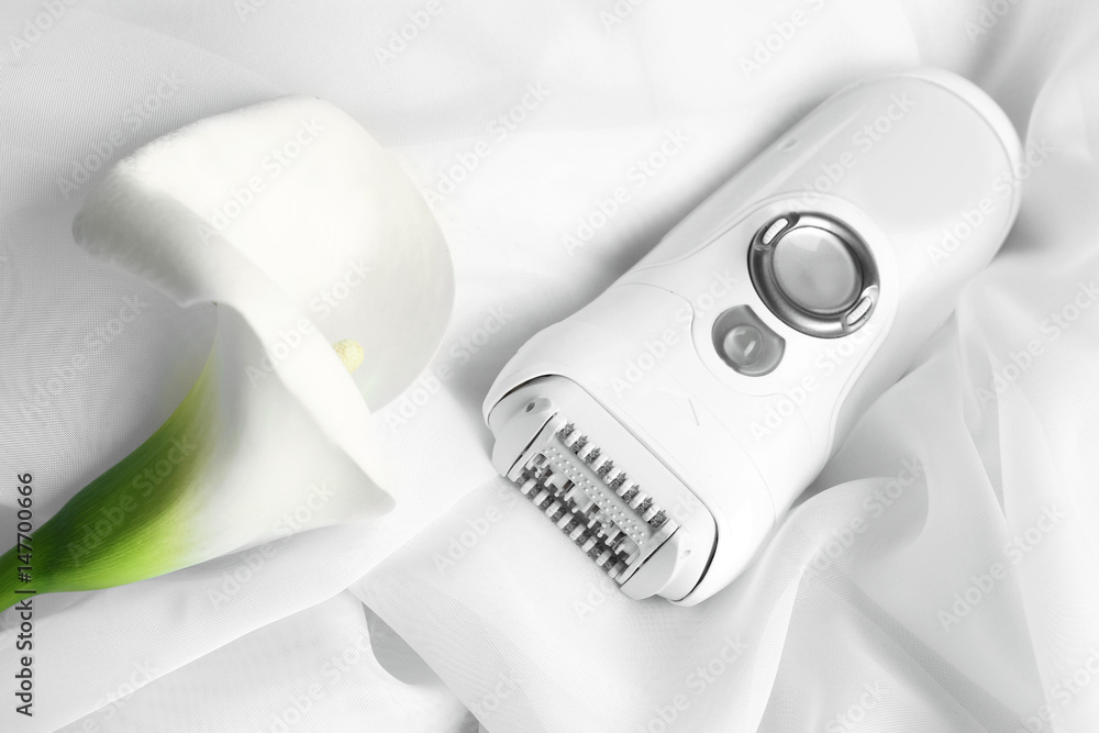 Modern epilator and flower on cloth Modern epilator and flower on cloth