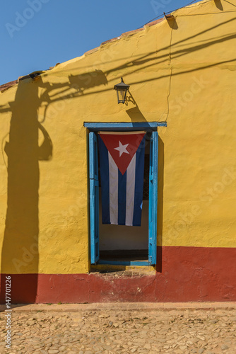 Cuban flag on yellow house   in the UNESCO World Heritage city center of Trinidad Cuba. © dannywilde