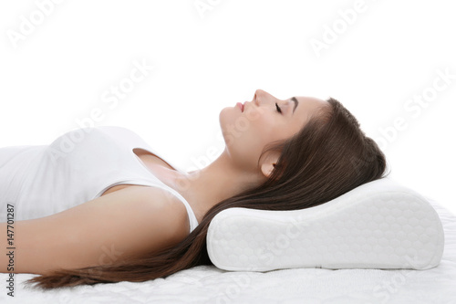 Young woman sleeping on bed with orthopedic pillow against white background. Healthy posture concept photo