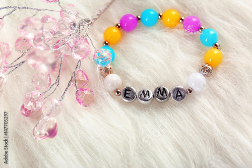 Composition with baby name bracelet on white fluffy background