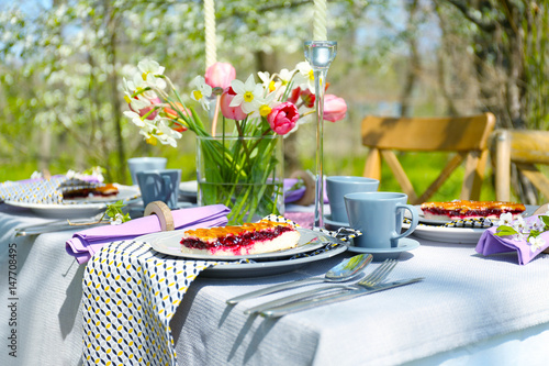 Table setting and cage with flowers in garden