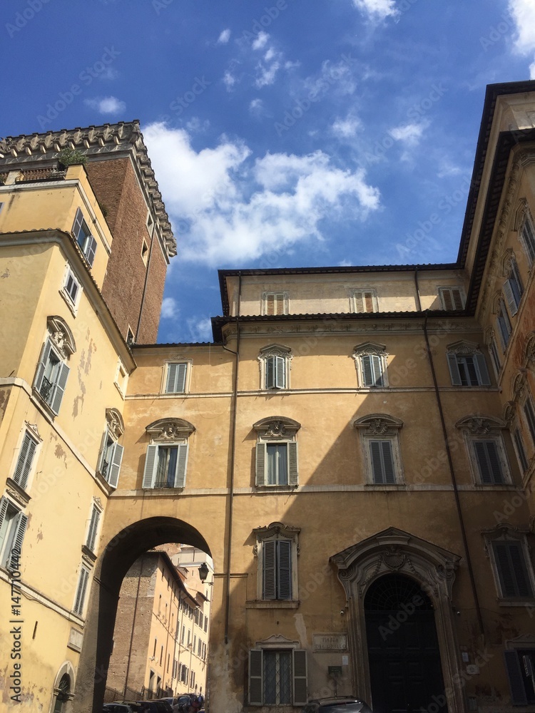 Casa ocra con arco su cielo blu, Roma, Italia