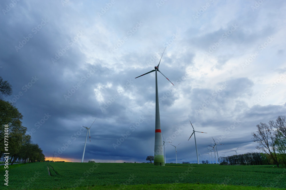 Wind turbines on a field during sunset Wind turbines on a field during sunset