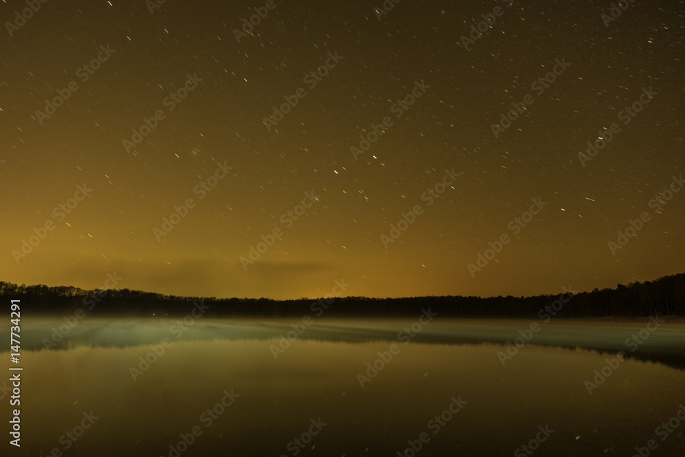 lights over a lake on a starry night