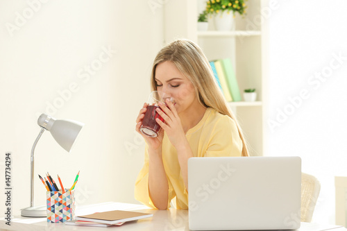 Beautiful young woman drink...