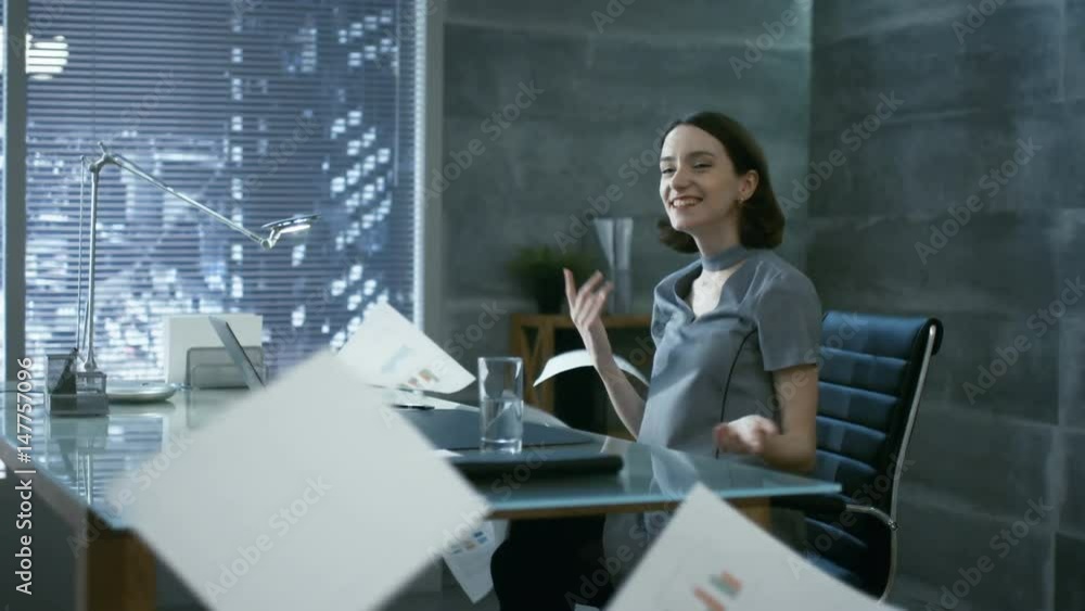 In a Private Office Young Beautiful Businesswoman Happily Throws Documents up in the Air. Her Office Looks Modern and Has Big City View. Shot on RED EPIC-W 8K Helium Cinema Camera. In a Private Office Young Beautiful Businesswoman Happily Throws Documents up in the Air. Her Office Looks Modern and Has Big City View. Shot on RED EPIC-W 8K Helium Cinema Camera.