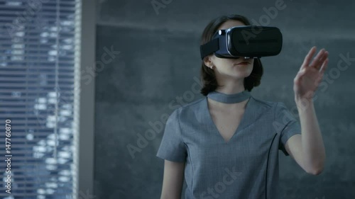 Stylish Young Woman Uses Virtual Reality Headset. She's chief IT Engineer for a New Promising Software Company.   Shot on RED EPIC-W 8K Helium Cinema Camera. photo