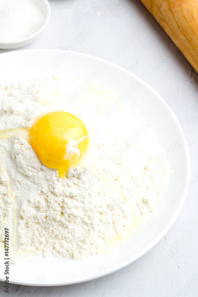 Flour, yolk and rolling pin on a white background. Flour, yolk and rolling pin on a white background.