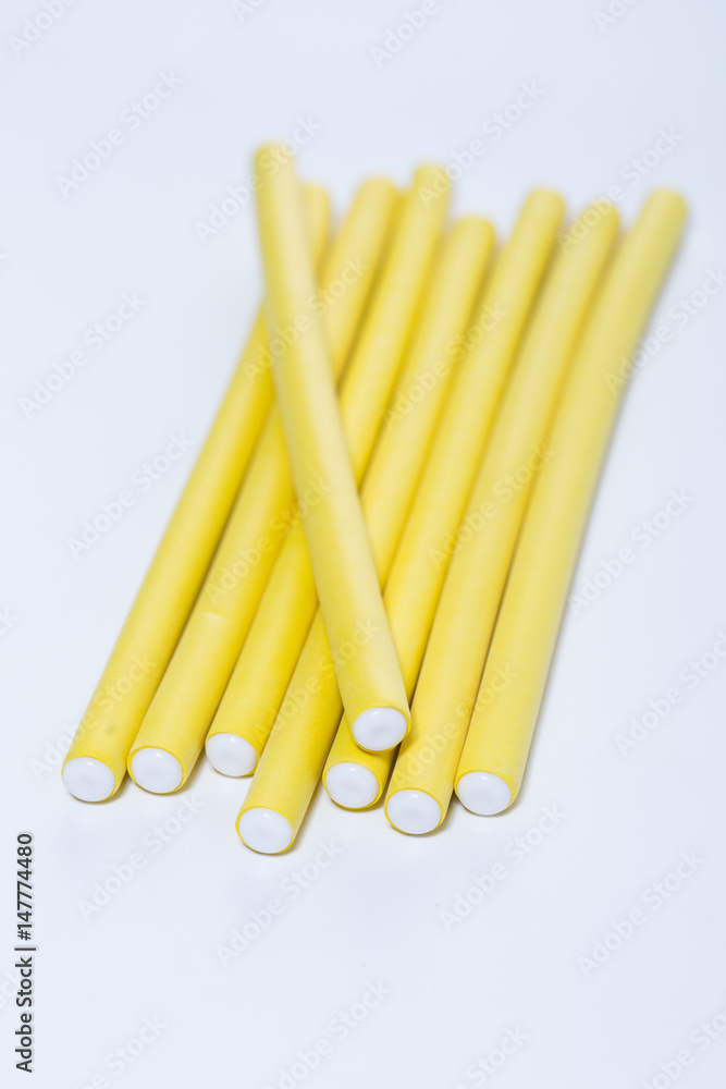 Yellow hair curlers on white