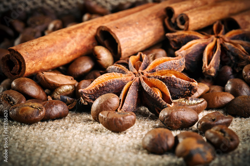 Coffee beans, ground coffee and cinnamon on burlap. © Anna