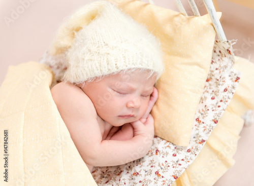 kid napping in cute yellow knitted hat