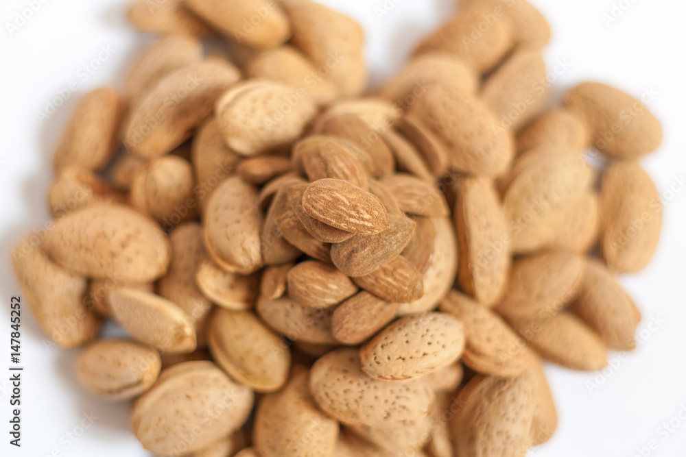 Almonds heart on isolated on white background, almonds in shells in the shape of a heart with some purified nuts on the top, happy valentines day, simplicity Almonds heart on isolated on white background, almonds in shells in the shape of a heart with some purified nuts on the top, happy valentines day, simplicity