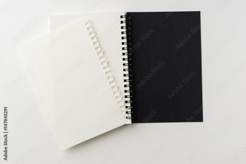 Business concept - Top view of spiral blank notebook on white background desk for mockup Business concept - Top view of spiral blank notebook on white background desk for mockup