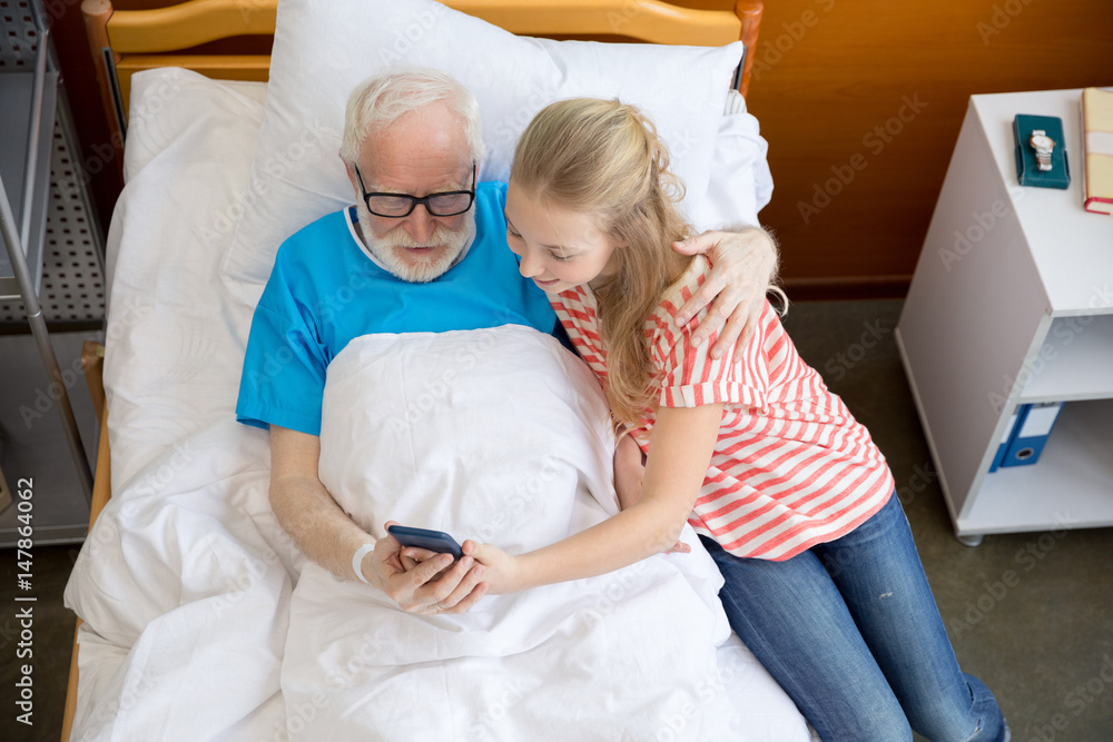 Obraz premium grandfather and child using smartphone