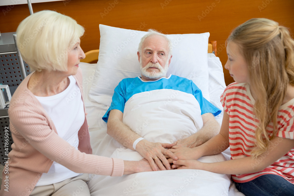 Fototapeta premium grandmother and grandfather holding hands with patient