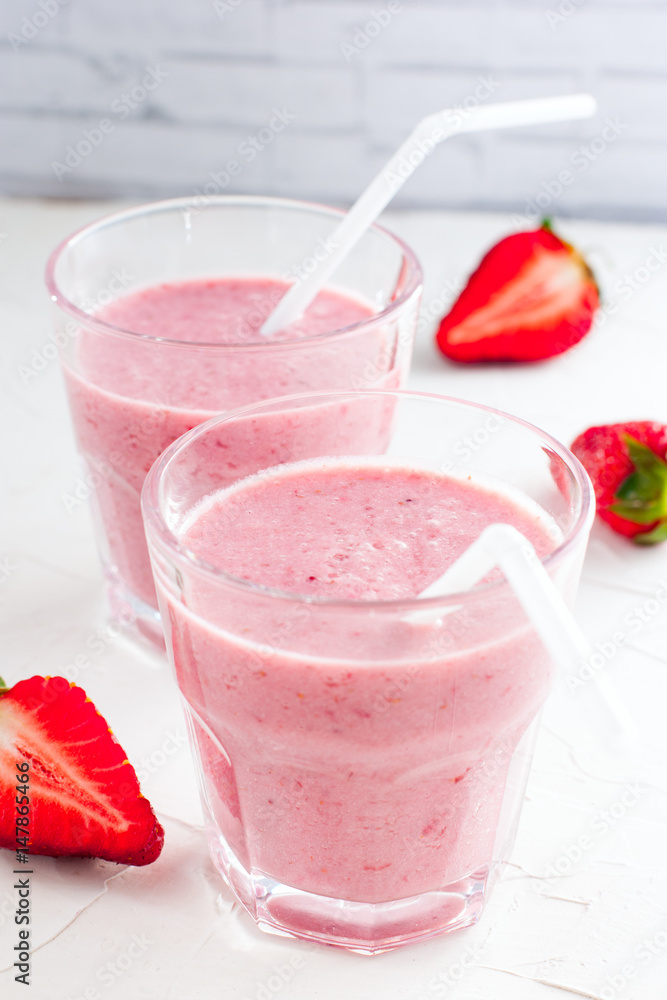 Summer chilled milkshake with strawberries in glass glasses, selective focus Summer chilled milkshake with strawberries in glass glasses, selective focus