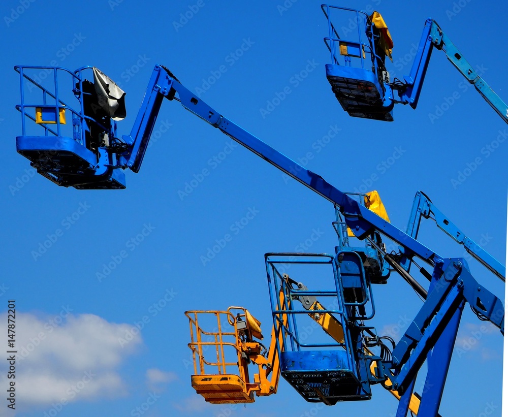 custom made wallpaper toronto digitalA group of cherry pickers in the air seen from the side,  against a blue sky with some coluds