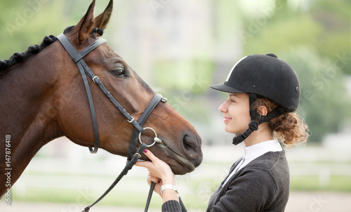 Attractive Young Woman Looking at her Horse © AlexanderNovikov