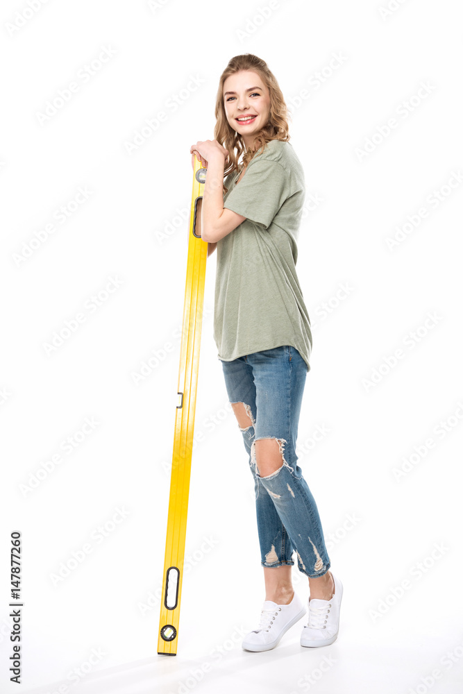 Smiling young woman posing with level tool isolated on white, renovation concept Smiling young woman posing with level tool isolated on white, renovation concept