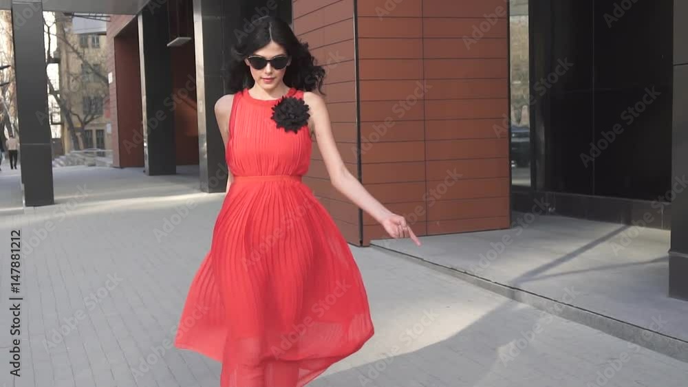 Sexy girl in red dress smiles. Girl with beautiful legs in a windswept dress. slow motion Sexy girl in red dress smiles. Girl with beautiful legs in a windswept dress. slow motion
