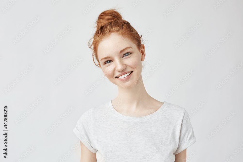 Portrait of young beautiful ginger woman with freckles cheerfuly smiling looking at camera. Isolated on white background. Copy space. Portrait of young beautiful ginger woman with freckles cheerfuly smiling looking at camera. Isolated on white background. Copy space.