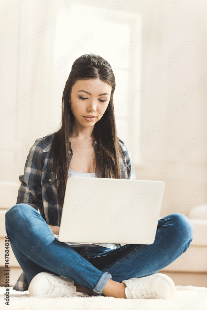 woman sitting on floor and working on laptop woman sitting on floor and working on laptop