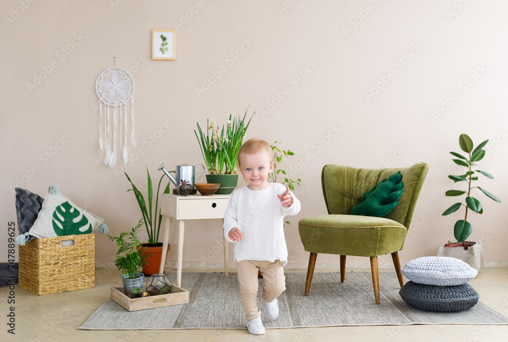 Running happy smiling little girl in the light room