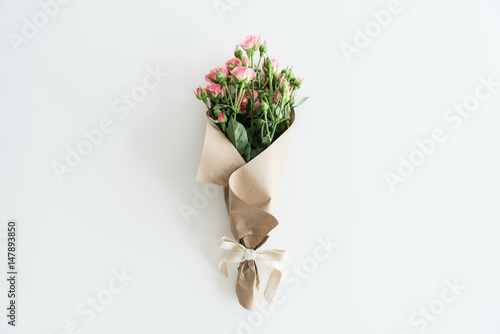 pink roses bouquet in kraft paper isolated on white with copy space, wedding flowers bouquet concept photo