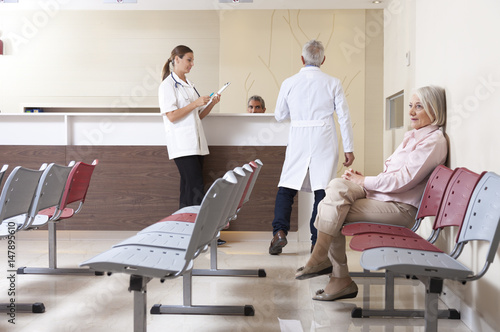 фотографія Doctors and patient discussing in hospital waiting room