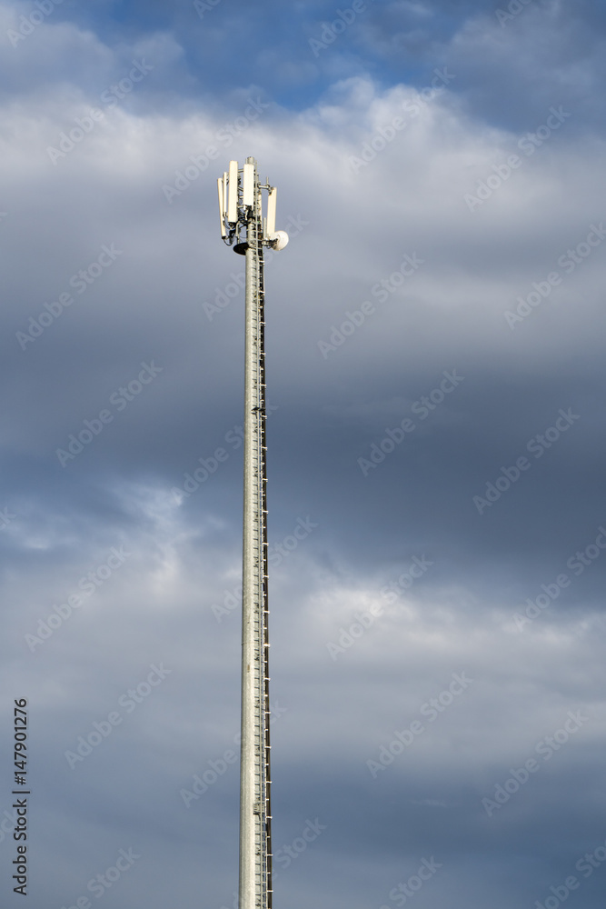 Antenna tower of cellular and communication systems over a cloudy sky Antenna tower of cellular and communication systems over a cloudy sky