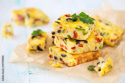 Homemade vegetarian rice frittata with zucchini, bell pepper and olives photo