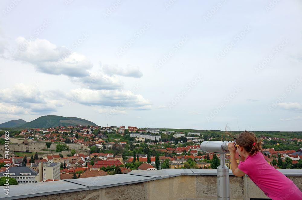 little girl looking through sightseeing binoculars on Eger Hungary