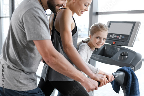 Happy family workout on treadmill, side view