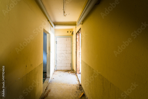 Different doors to exit. Corridor in a ruined house. Door walled brick. The concept of "getting out of a difficult situation"