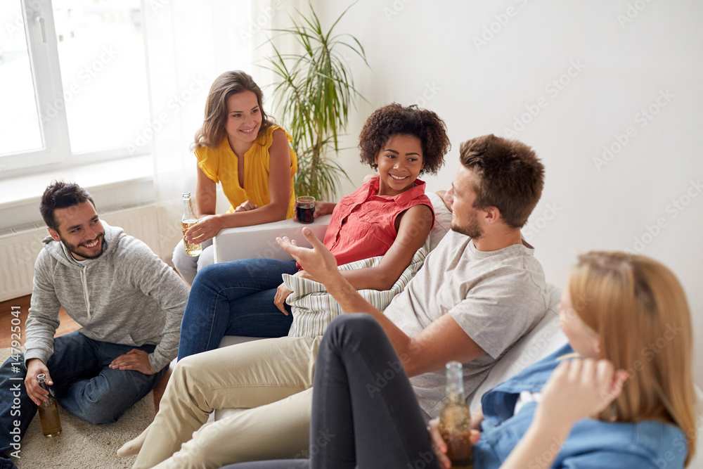 group of happy friends with drinks talking at home group of happy friends with drinks talking at home