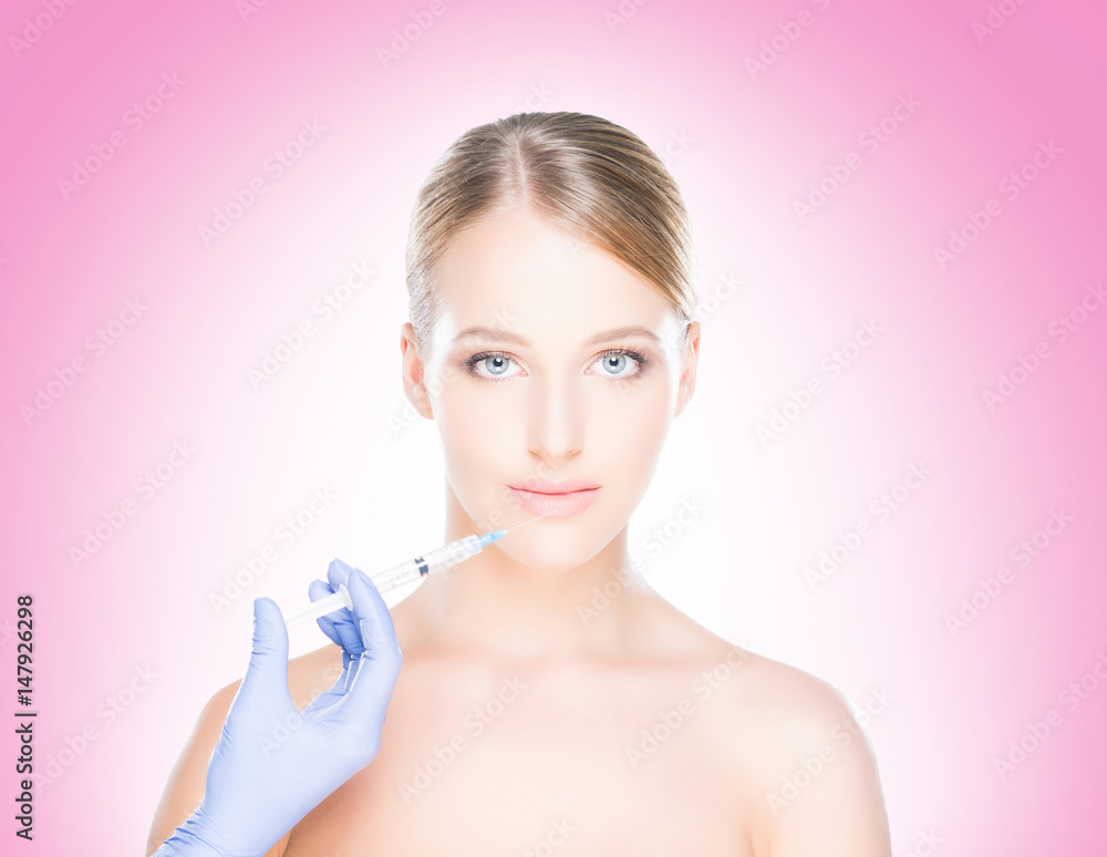 Young, beautiful and healthy woman having skin injections over pink background. Plastic surgery concept. Young, beautiful and healthy woman having skin injections over pink background. Plastic surgery concept.