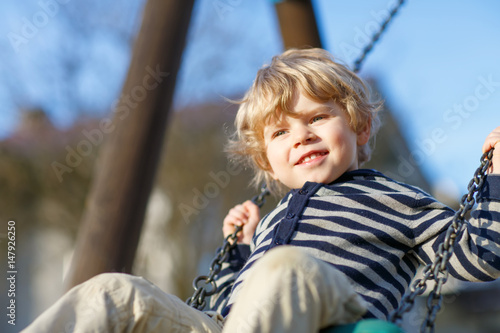 Portrait of toddler boy having fun on outdoor playground