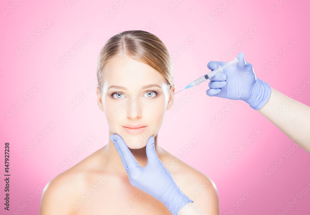 Doctor injecting in a beautiful face of a young woman. Plastic surgery concept. Doctor injecting in a beautiful face of a young woman. Plastic surgery concept.