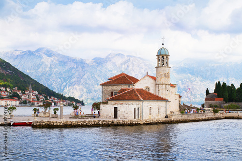 Fjord in Adriatic Sea. Our Lady of the Rock island and Church in Perast on shore of Boka Kotor bay (Boka Kotorska), Montenegro, Europe. Kotor Bay is a UNESCO World Heritage Site