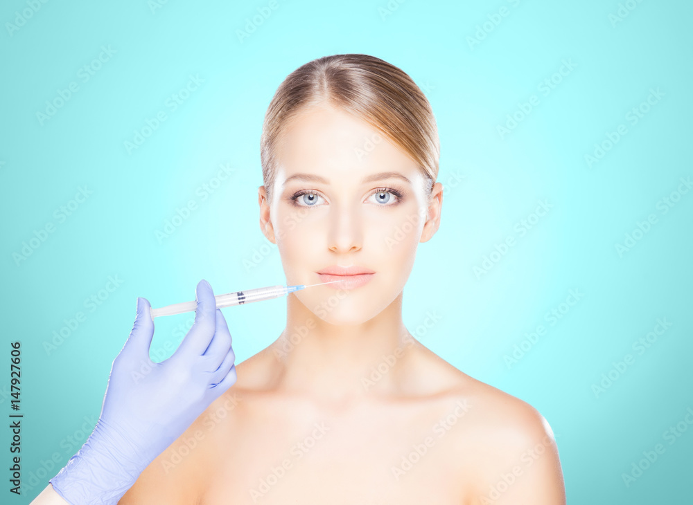 Doctor injecting in a beautiful face of a young woman. Plastic surgery concept. Doctor injecting in a beautiful face of a young woman. Plastic surgery concept.