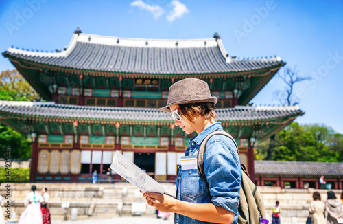Obraz na płótnie Young woman tourist with map in hand on the background of Asian architecture, travel to Korea, Seoul Asia w salonie
