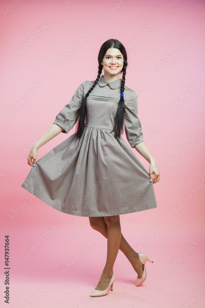 Beautiful woman in retro style dress over pink background Beautiful woman in retro style dress over pink background