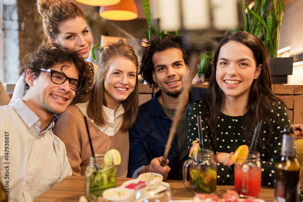 friends taking selfie by smartphone at bar or cafe friends taking selfie by smartphone at bar or cafe