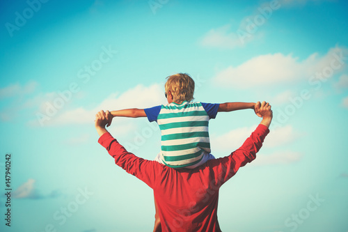 happy father and son playing on sky