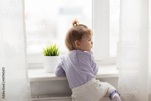 lovely little girl at home window