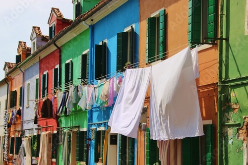   Bright colored houses and laundry hung up to dry on the island Burano, situated in the Lagoon of Venice, Italy, Europe.    © utamaria