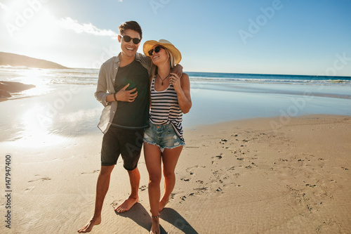 Romantic young couple walking on beach